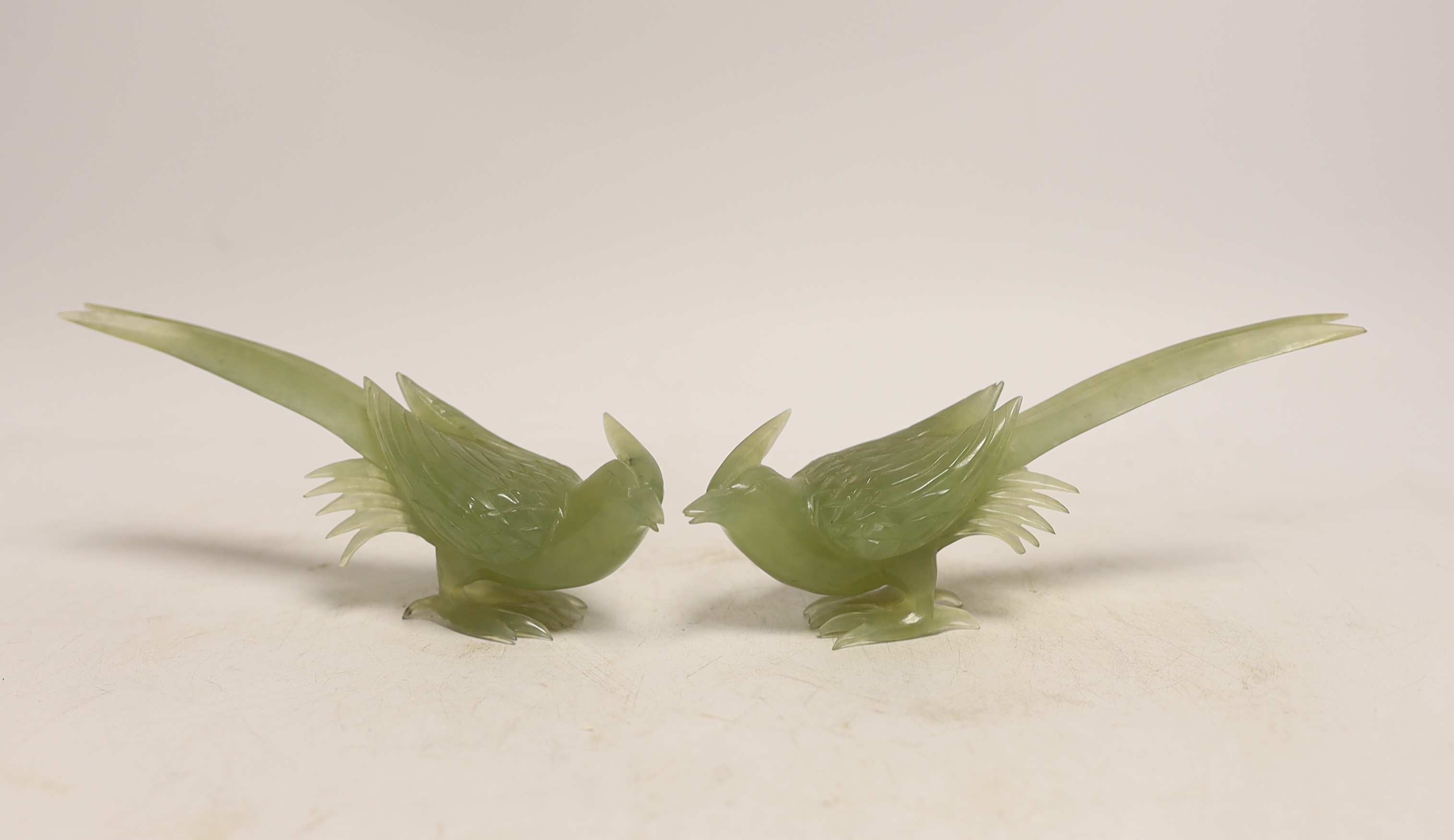 A pair of carved bowenite jade birds on stands, boxed